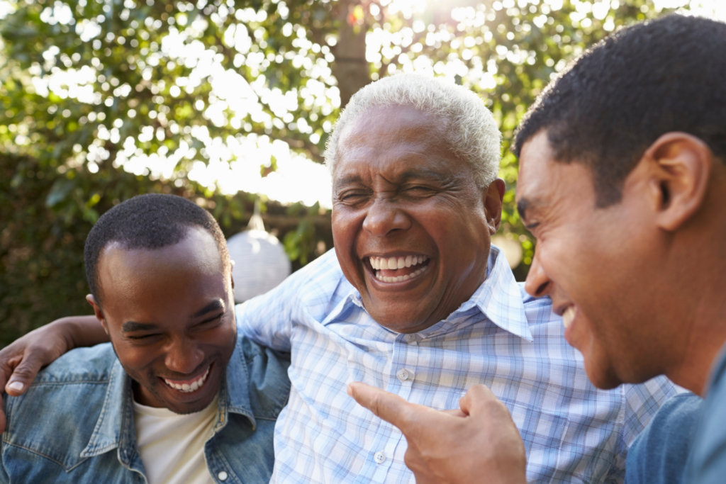 Senior man embracing with two young men