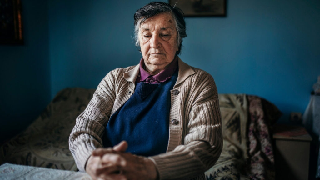 Senior woman seated with hands folded